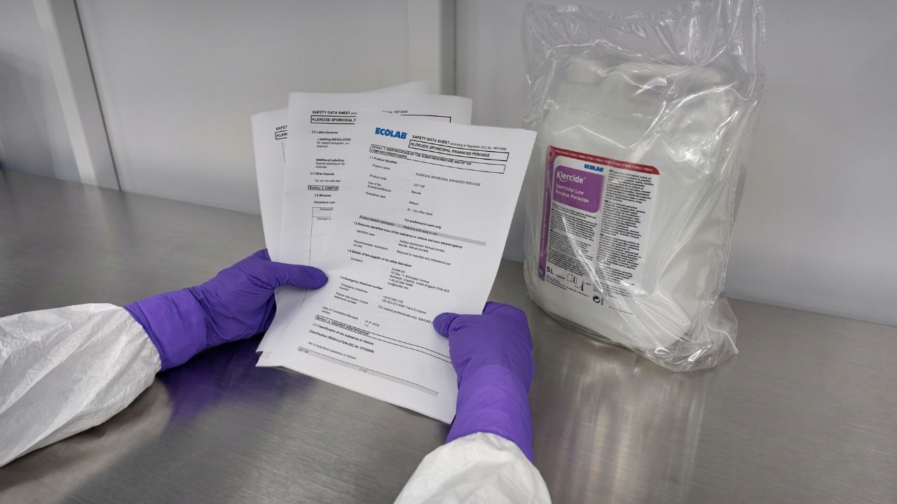 Cleanroom operator holding a safety data sheet